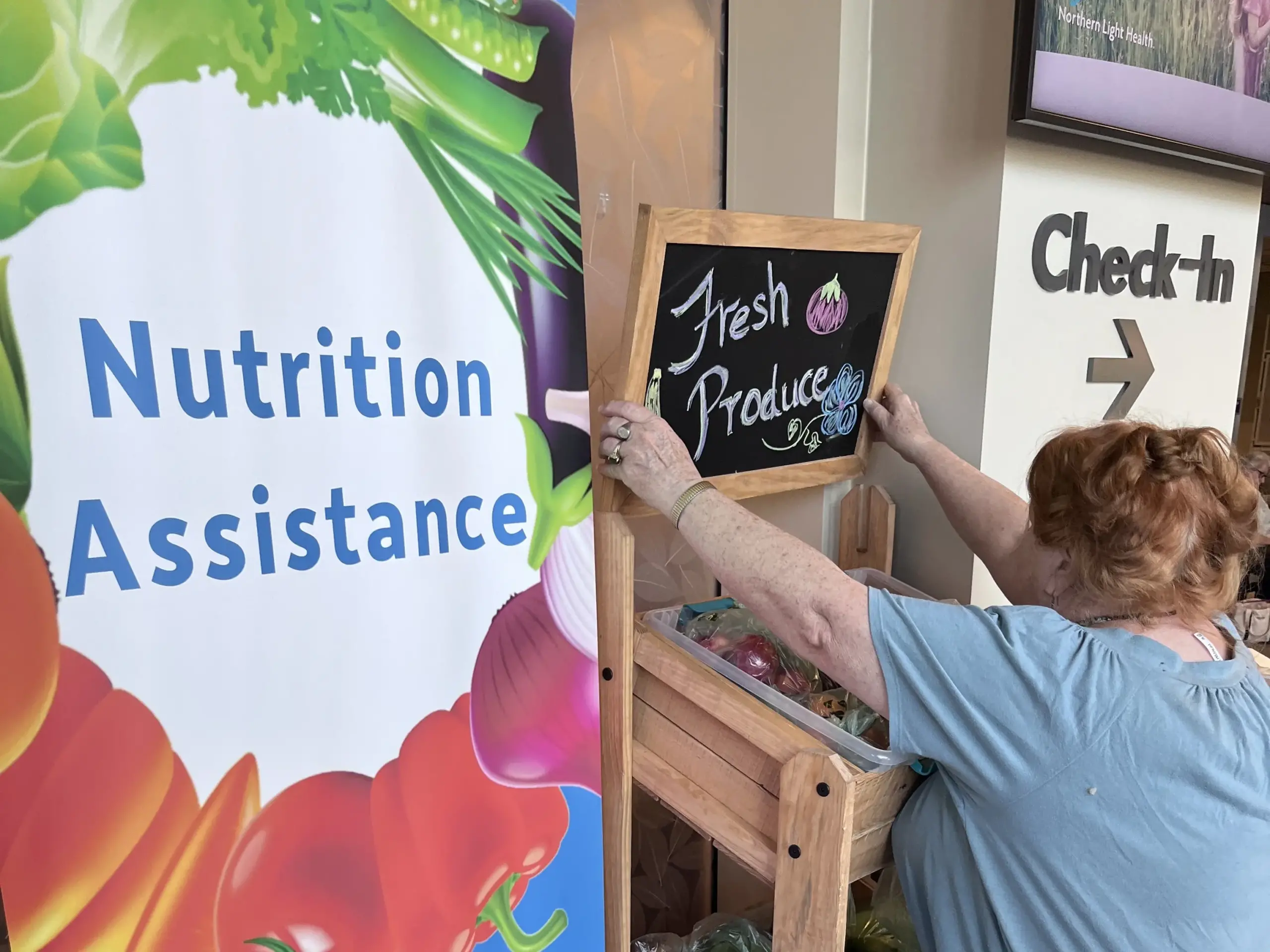 Christine B Foundation Pull Up and Woman putting sign over three baskets of food.