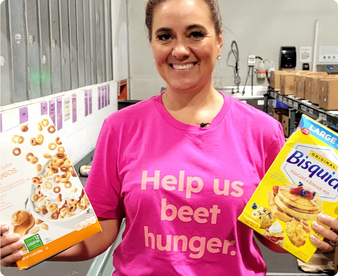 A woman in a "help us beet hunger shirt" with Bisquick and Cheerios.