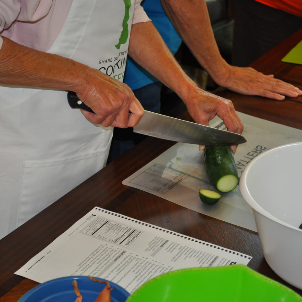 People slicing up zucchini 