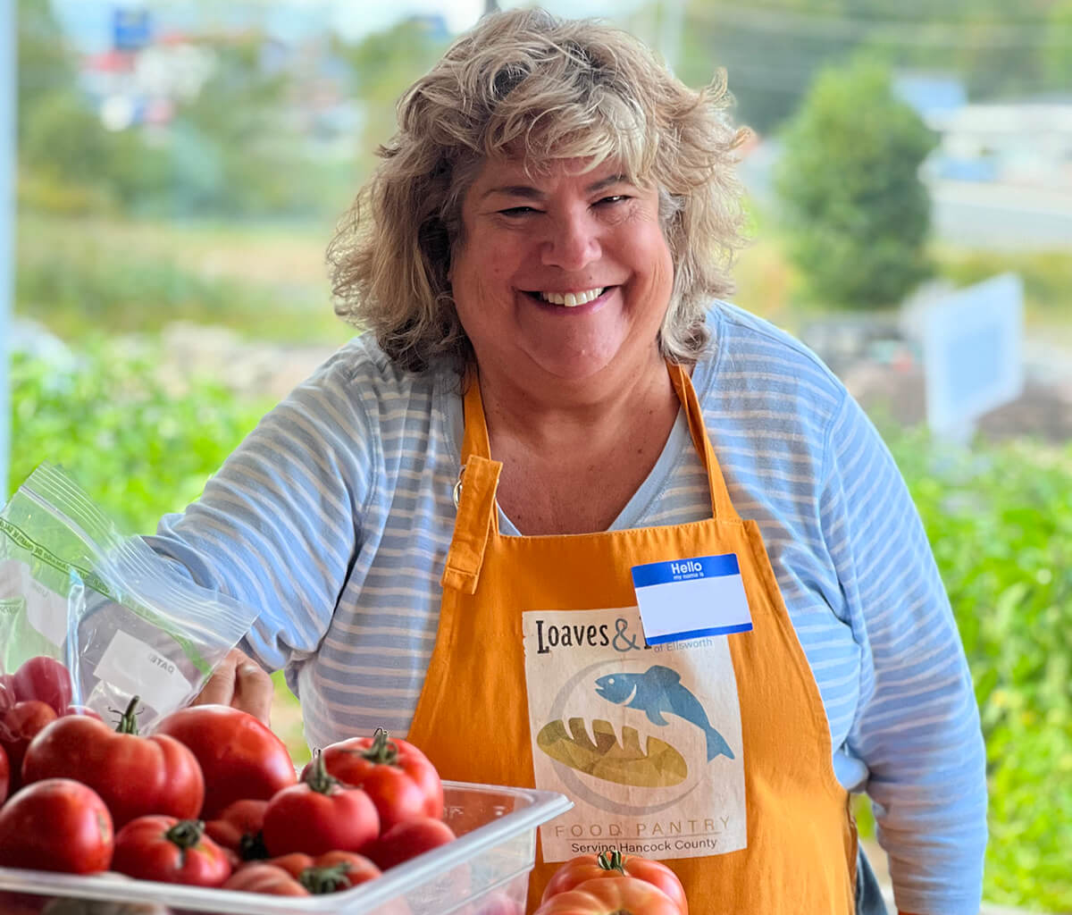 A volunteer smiling working with Loaves and Fishes. 