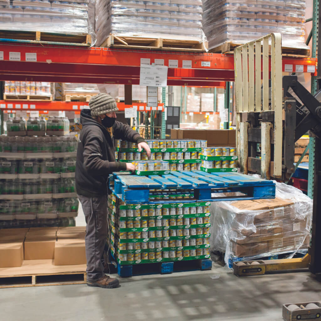 Man unpacking many cans of food