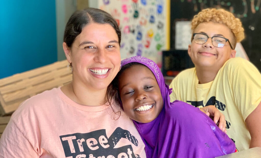 Staff at Tree Street Youth nonprofit with two students