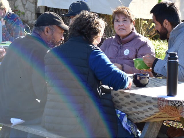 Volunteers around a table smiling and talking. 